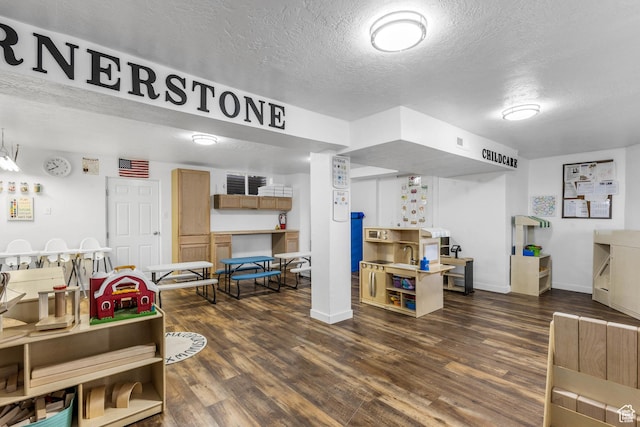 interior space featuring a textured ceiling, visible vents, dark wood-style flooring, and baseboards