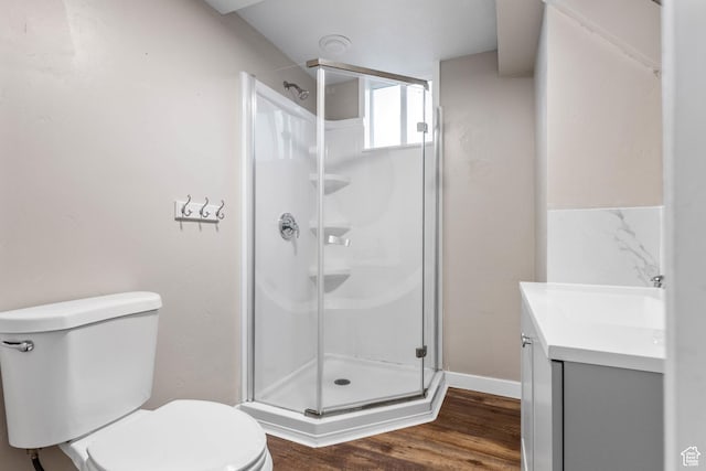 full bath featuring vanity, toilet, wood finished floors, and a shower stall