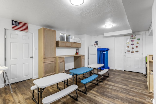 interior space featuring baseboards, dark wood-style floors, and a textured ceiling