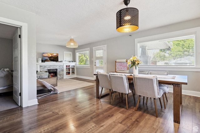 1923 S 600 E, Salt Lake City, UT 84105 - dining space featuring a textured ceiling, baseboards, a stone fireplace, and wood finished floors