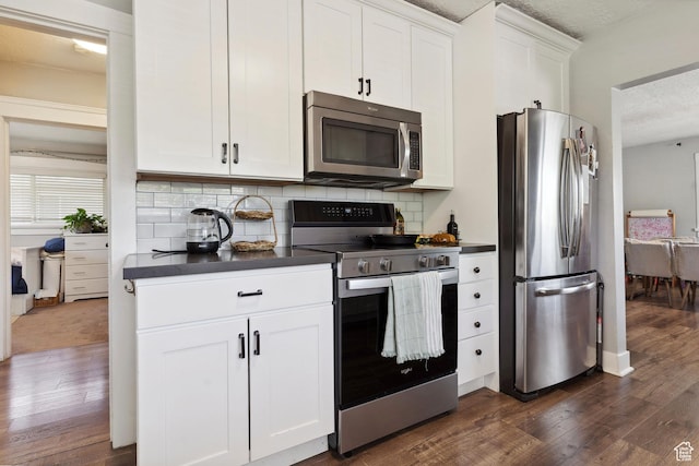 1923 S 600 E, Salt Lake City, UT 84105 - kitchen featuring dark wood finished floors, decorative backsplash, dark countertops, stainless steel appliances, and white cabinets