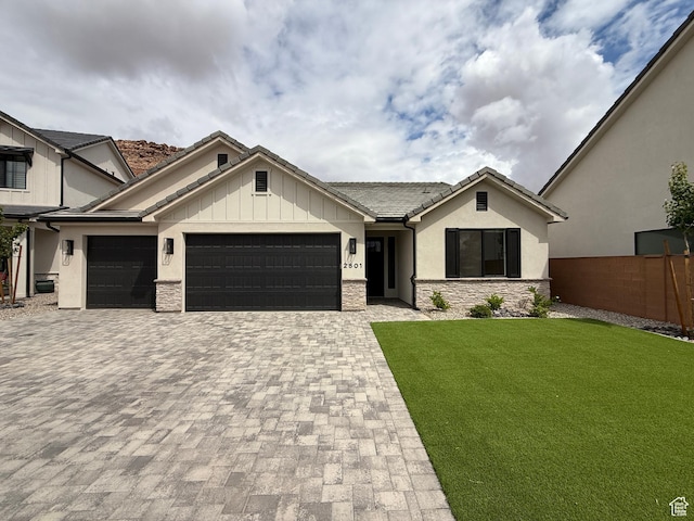 view of front facade with an attached garage, stone siding, stucco siding, a front lawn, and decorative driveway