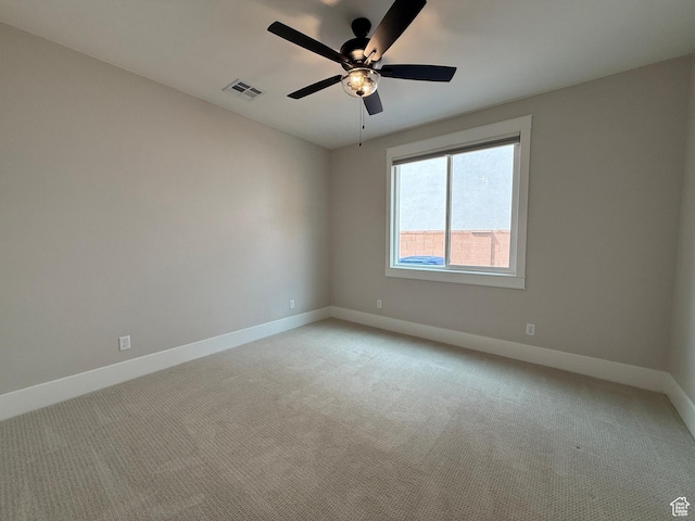 empty room with visible vents, baseboards, ceiling fan, and light carpet