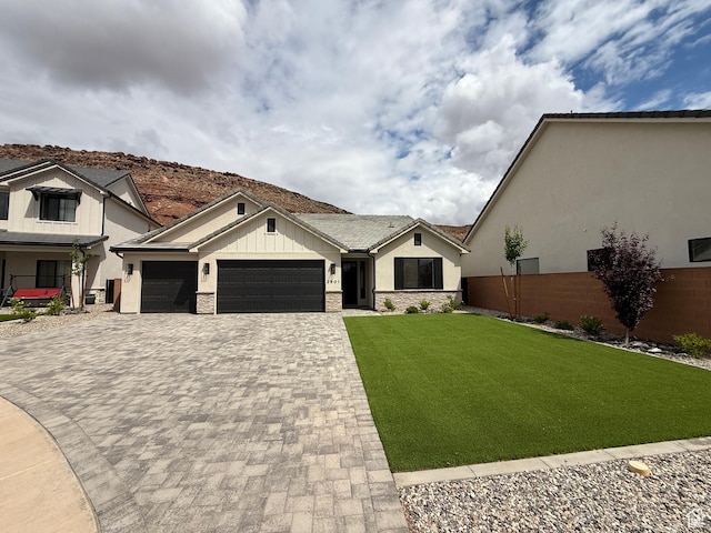 view of front facade featuring a garage, stucco siding, fence, decorative driveway, and a front yard