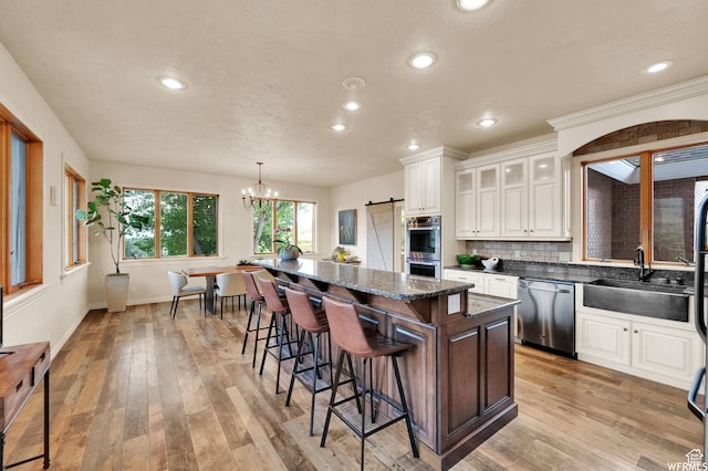 320 S Old Farm Ln E, Coalville, UT 84017 - kitchen with a breakfast bar area, a barn door, a center island, a sink, and stainless steel appliances