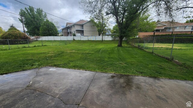 view of yard featuring fence and a patio