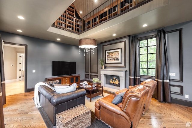 680 S Davis Blvd, Bountiful, UT 84010 - living room with a warm lit fireplace, wood finished floors, recessed lighting, a high ceiling, and baseboards