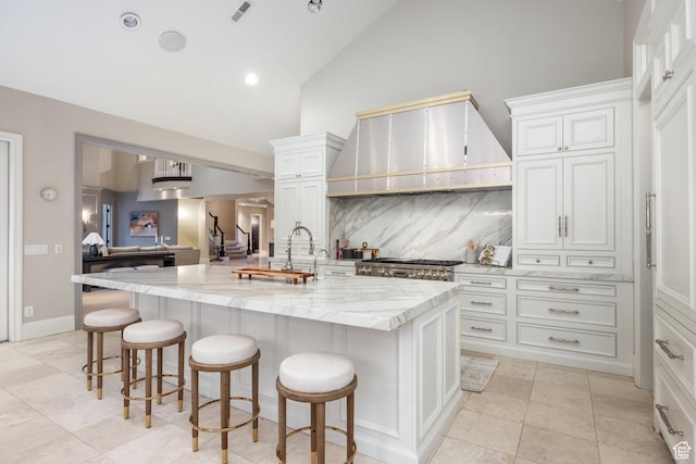 680 S Davis Blvd, Bountiful, UT 84010 - kitchen featuring a kitchen breakfast bar, tasteful backsplash, light stone counters, and custom range hood