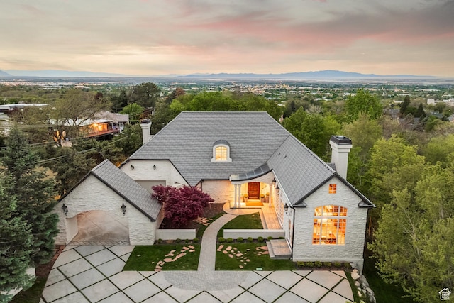 680 S Davis Blvd, Bountiful, UT 84010 - view of front of house with a chimney, stone siding, a garage, and driveway