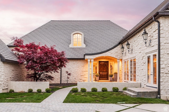 680 S Davis Blvd, Bountiful, UT 84010 - exterior entry at dusk featuring a high end roof, french doors, and stone siding