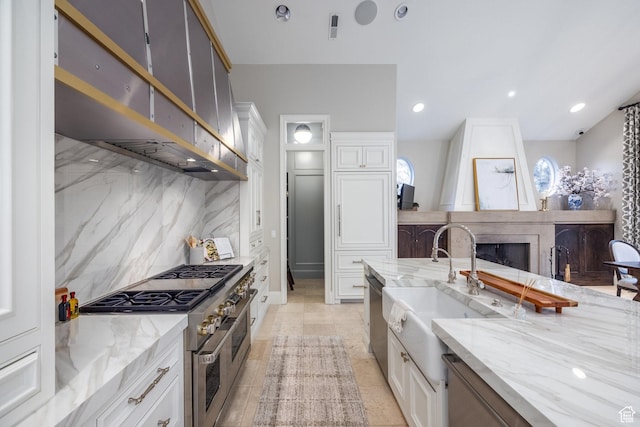 680 S Davis Blvd, Bountiful, UT 84010 - kitchen featuring a sink, ventilation hood, decorative backsplash, stainless steel appliances, and a fireplace