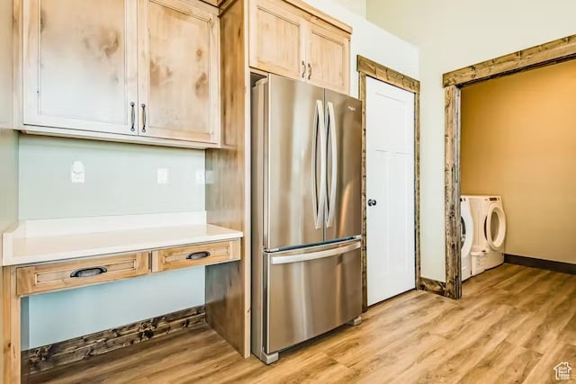 2869 S Chukar Dr Unit 63, Garden City, UT 84028 - kitchen with freestanding refrigerator, light wood-type flooring, washer and dryer, light countertops, and baseboards