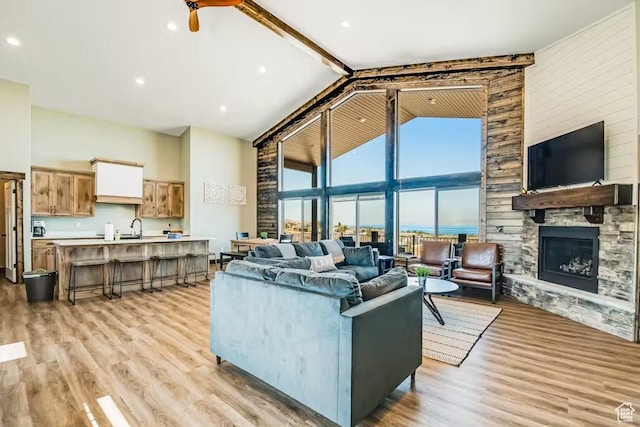 2869 S Chukar Dr Unit 63, Garden City, UT 84028 - living area featuring a stone fireplace, light wood finished floors, and high vaulted ceiling
