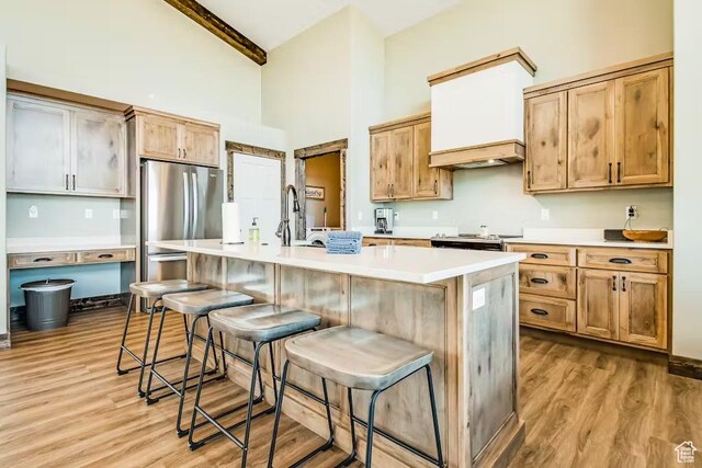 2869 S Chukar Dr Unit 63, Garden City, UT 84028 - kitchen with light wood finished floors, freestanding refrigerator, a kitchen breakfast bar, and high vaulted ceiling