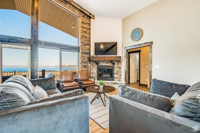 2869 S Chukar Dr Unit 63, Garden City, UT 84028 - living room with high vaulted ceiling, baseboards, a stone fireplace, and wood finished floors