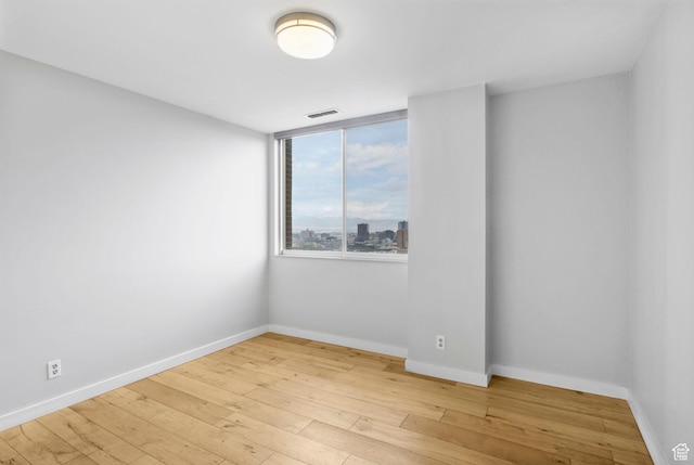 777 E S Temple S Unit 11B, Salt Lake City, UT 84102 - empty room featuring light wood finished floors, visible vents, and baseboards