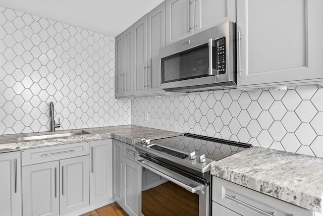 777 E S Temple S Unit 11B, Salt Lake City, UT 84102 - kitchen featuring a sink, stainless steel appliances, tasteful backsplash, and light wood-style floors