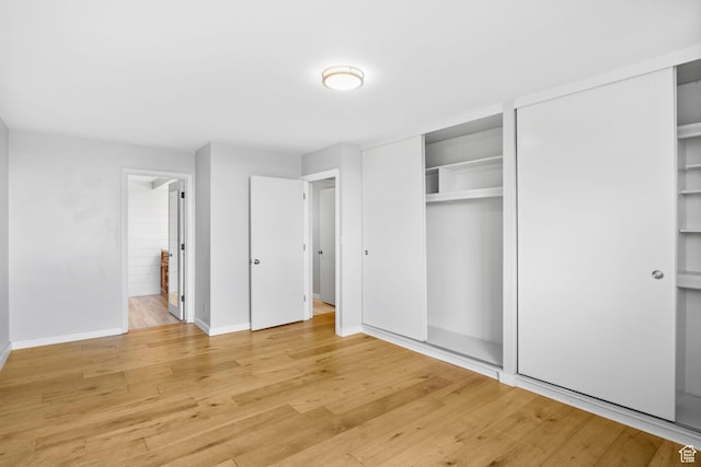 777 E S Temple S Unit 11B, Salt Lake City, UT 84102 - unfurnished bedroom featuring light wood finished floors, two closets, and baseboards