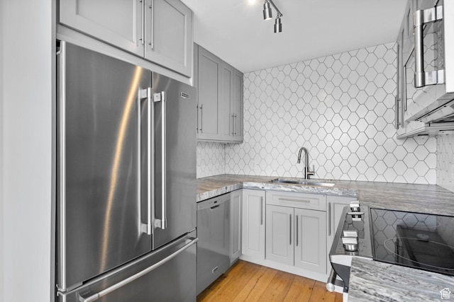 777 E S Temple S Unit 11B, Salt Lake City, UT 84102 - kitchen featuring light wood-style flooring, a sink, stainless steel appliances, gray cabinets, and tasteful backsplash