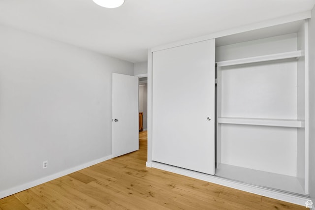 777 E S Temple S Unit 11B, Salt Lake City, UT 84102 - unfurnished bedroom with wood finished floors, a closet, and baseboards
