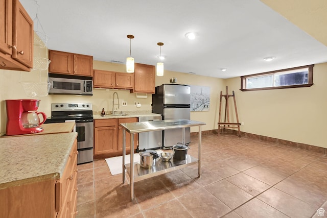 kitchen featuring stainless steel appliances, a sink, light countertops, and brown cabinetry