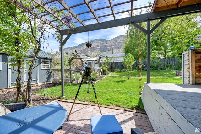 view of patio / terrace with a shed, a deck with mountain view, an outbuilding, and a pergola