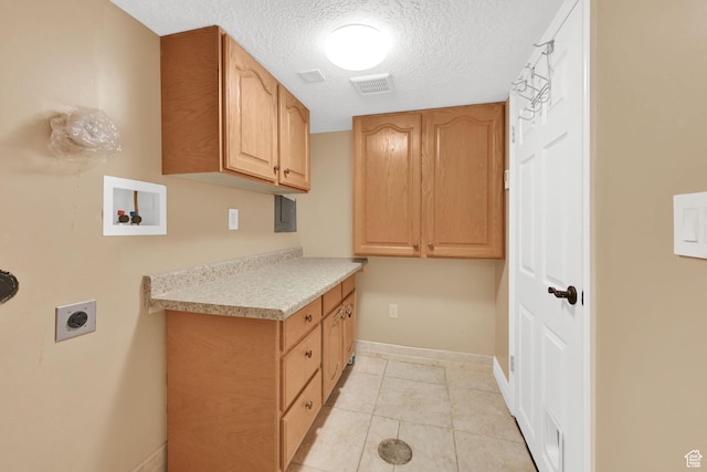 washroom featuring electric dryer hookup, cabinet space, baseboards, a textured ceiling, and washer hookup