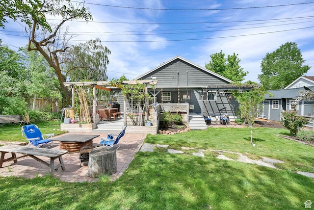 rear view of house with a fire pit, a wooden deck, and a patio area