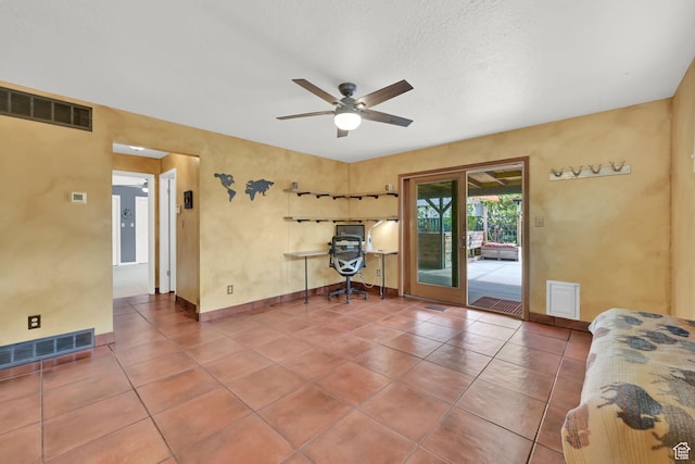 tiled living area with ceiling fan, an office area, and baseboards