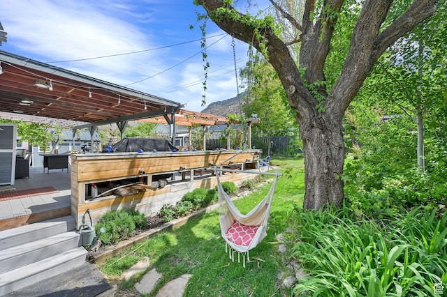 view of yard featuring a deck with mountain view and fence