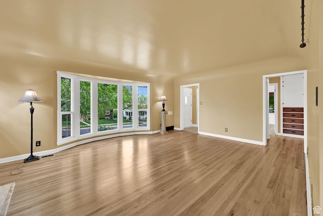 unfurnished living room with wood finished floors and baseboards