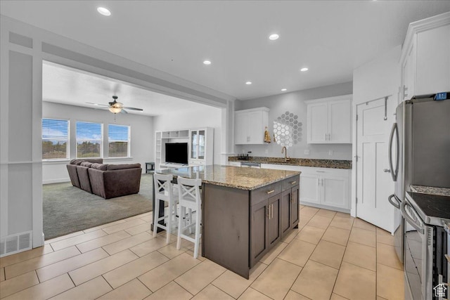 8072 N Rock Creek Cove Ln, Eagle Mountain, UT 84005 - kitchen with a sink, white cabinetry, open floor plan, a center island, and stainless steel range with electric cooktop