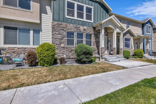 8072 N Rock Creek Cove Ln, Eagle Mountain, UT 84005 - view of front of home with a front yard, stone siding, and board and batten siding