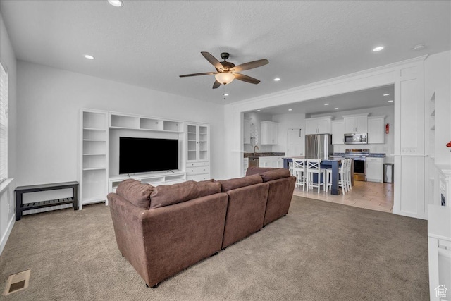 8072 N Rock Creek Cove Ln, Eagle Mountain, UT 84005 - living area with a ceiling fan, recessed lighting, a textured ceiling, visible vents, and light colored carpet
