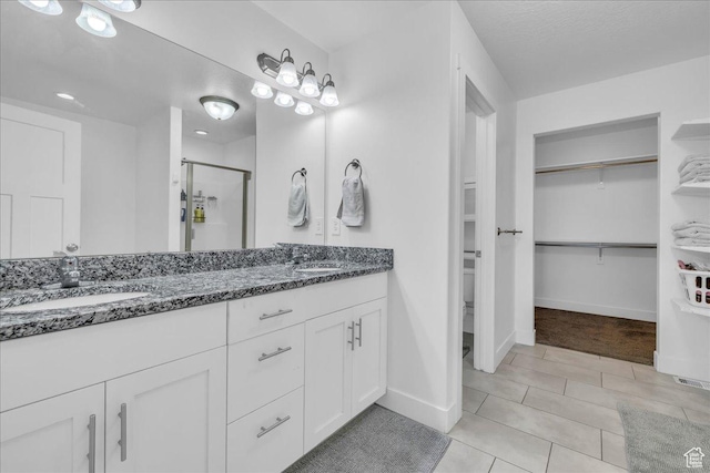 8072 N Rock Creek Cove Ln, Eagle Mountain, UT 84005 - full bathroom featuring double vanity, a shower stall, a spacious closet, and a sink