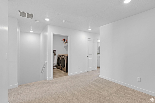 unfurnished room featuring washing machine and dryer, recessed lighting, baseboards, visible vents, and light colored carpet