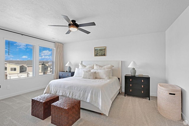 carpeted bedroom with ceiling fan, a textured ceiling, and baseboards