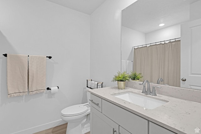 bathroom featuring wood finished floors, toilet, vanity, baseboards, and curtained shower