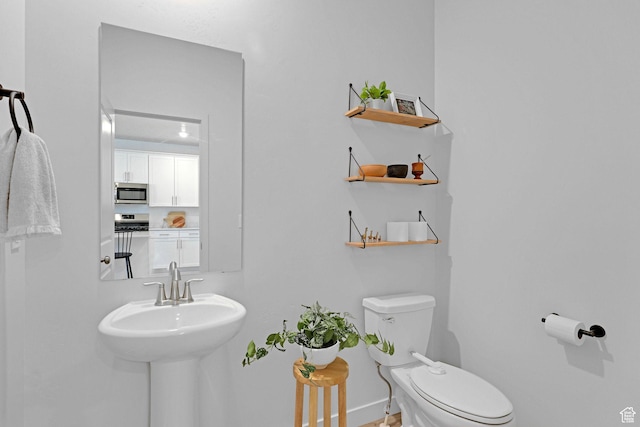 half bath featuring toilet and baseboards