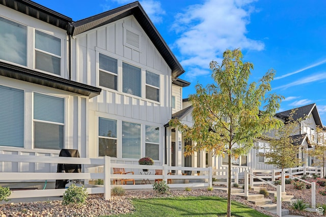 back of house with board and batten siding and a fenced front yard