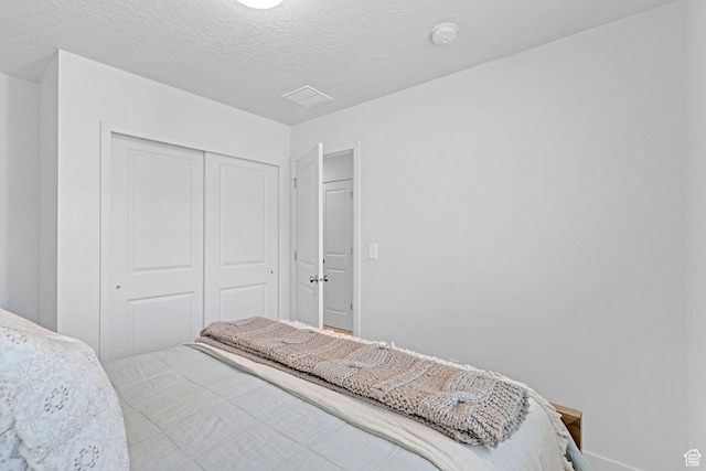 bedroom featuring a textured ceiling and a closet
