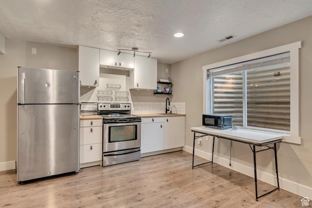 13623 S Blayde Dr W, Herriman, UT 84096 - kitchen with a sink, stainless steel appliances, tasteful backsplash, white cabinetry, and baseboards