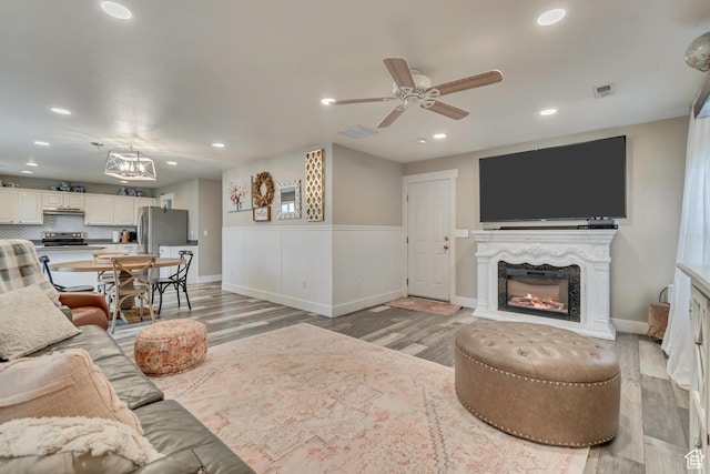 13623 S Blayde Dr W, Herriman, UT 84096 - living area with a ceiling fan, light wood finished floors, a glass covered fireplace, and recessed lighting