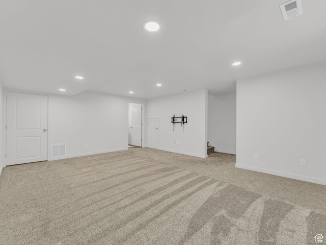 finished below grade area with carpet, visible vents, baseboards, and recessed lighting