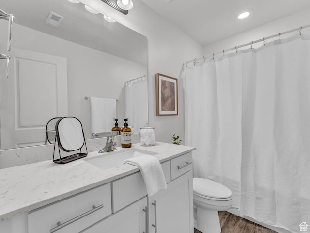 full bathroom featuring recessed lighting, toilet, visible vents, vanity, and wood finished floors
