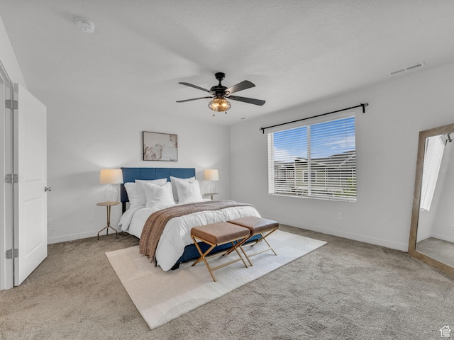 carpeted bedroom with baseboards, a ceiling fan, and visible vents