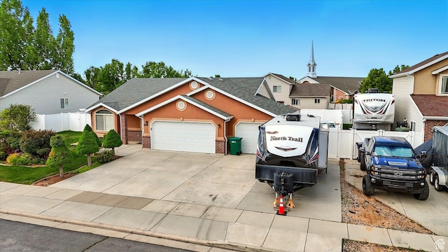view of front of property featuring an attached garage, fence, a shingled roof, brick siding, and driveway
