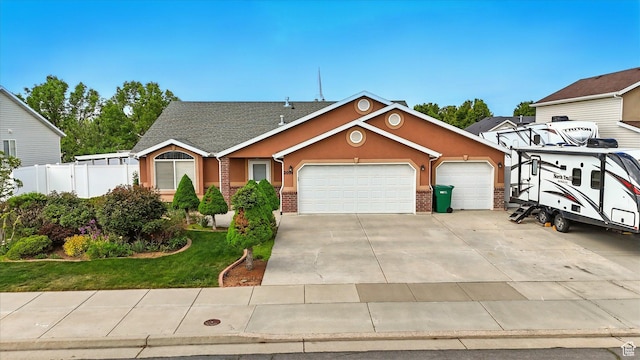 view of front of house featuring fence, an attached garage, stucco siding, concrete driveway, and a front yard