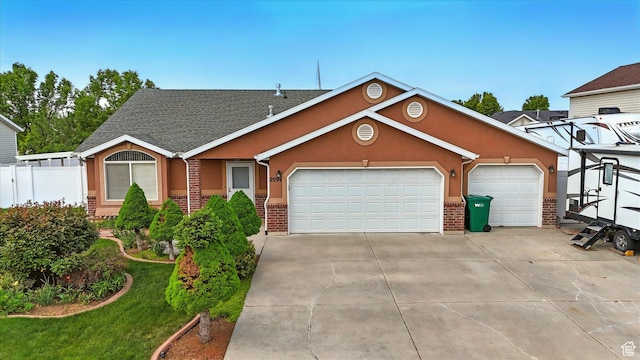 view of front of home featuring concrete driveway, stucco siding, brick siding, and an attached garage