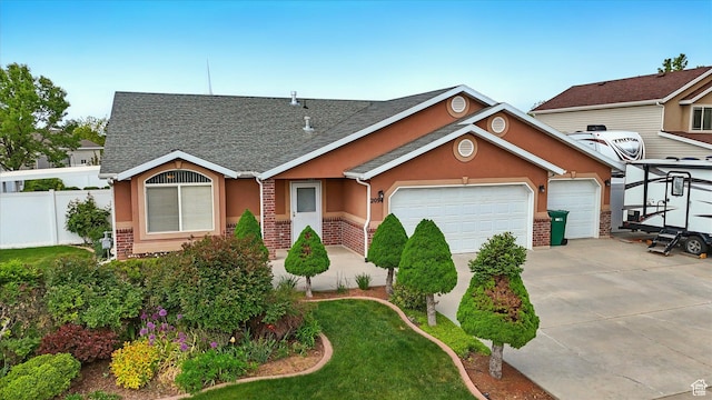 view of front of house with a garage, stucco siding, fence, concrete driveway, and roof with shingles